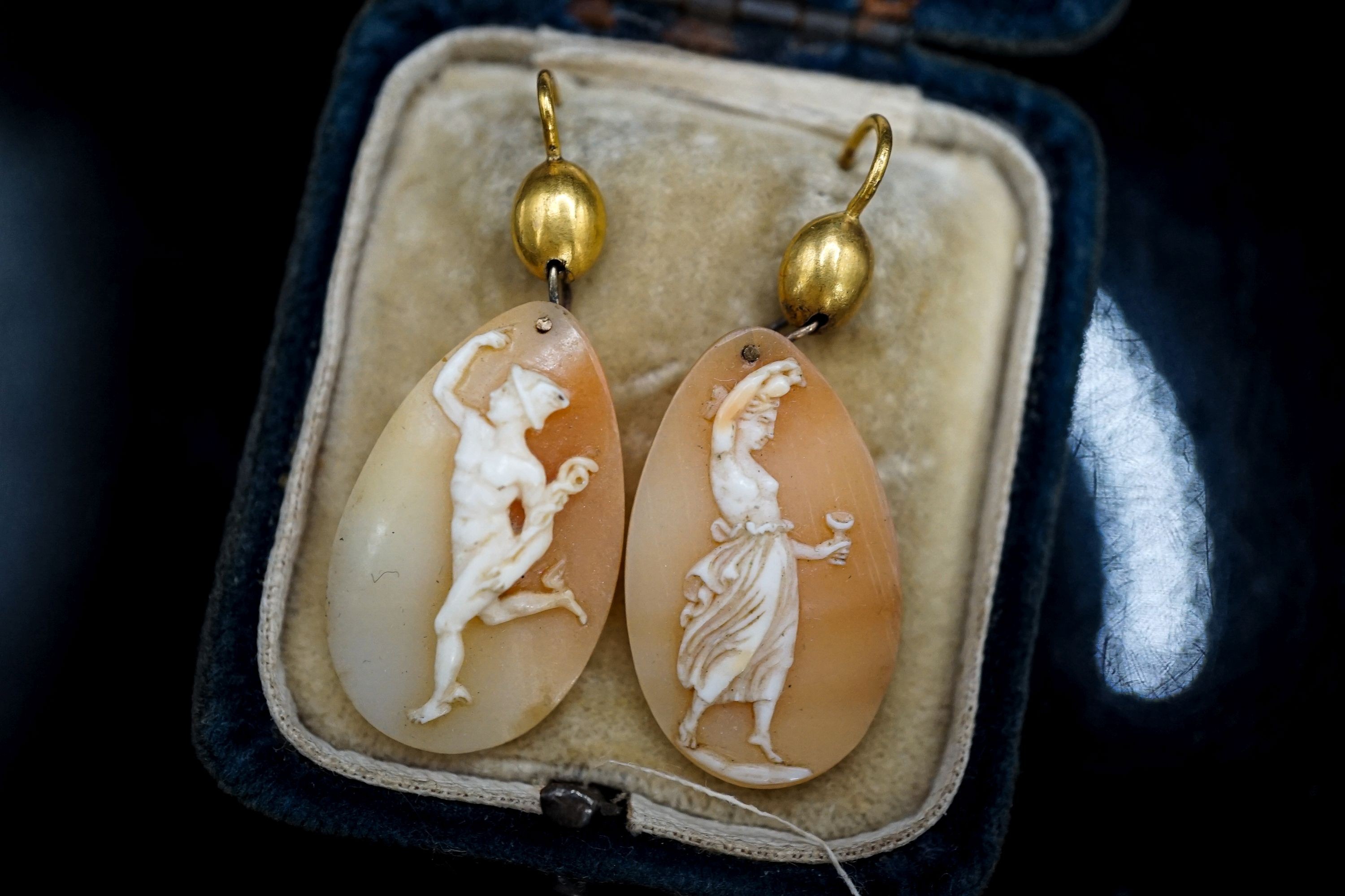 A pair of Victorian yellow metal and cameo shell ovoid earrings, carved with Mercury & Flora, shell 26mm.